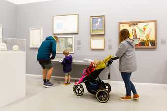 a family with a pram in the gallery