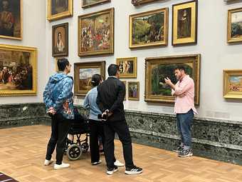 Person talking to a group of people in a gallery.