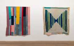 two colourful woven textiles are hung side by side from a white wall.