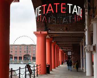 The Albert dock outside of Tate liverpool with a Tate sign.