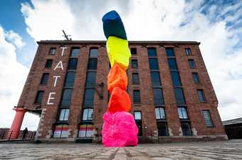 An image of Tate Liverpool with Ugo Rondinone's large colourful sculpture standing in the courtyard
